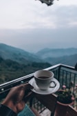 person holding white ceramic mug