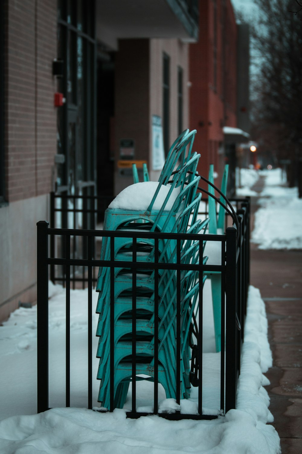 green metal fence covered with snow