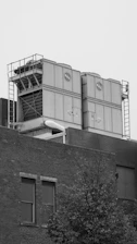 grayscale photo of building near tree