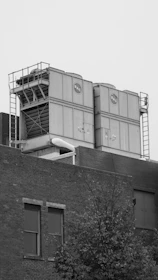grayscale photo of building near tree