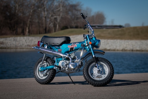 blue and black standard motorcycle on road during daytime