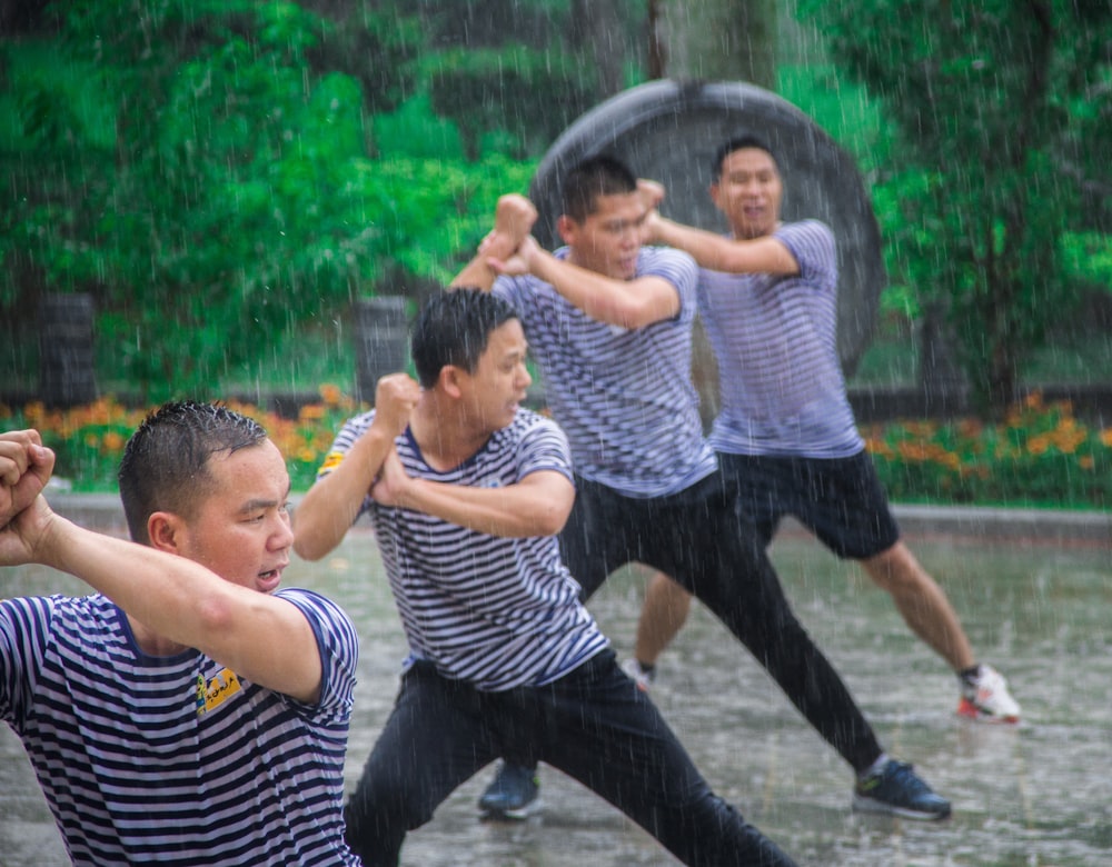 2 boys playing on water fountain during daytime