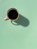 Artistic black and white shot of a coffee cup on a clean desk.