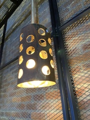 Modern metal lamp casting warm light on a textured wall.