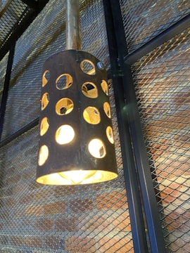 Modern metal lamp casting warm light on a textured wall.