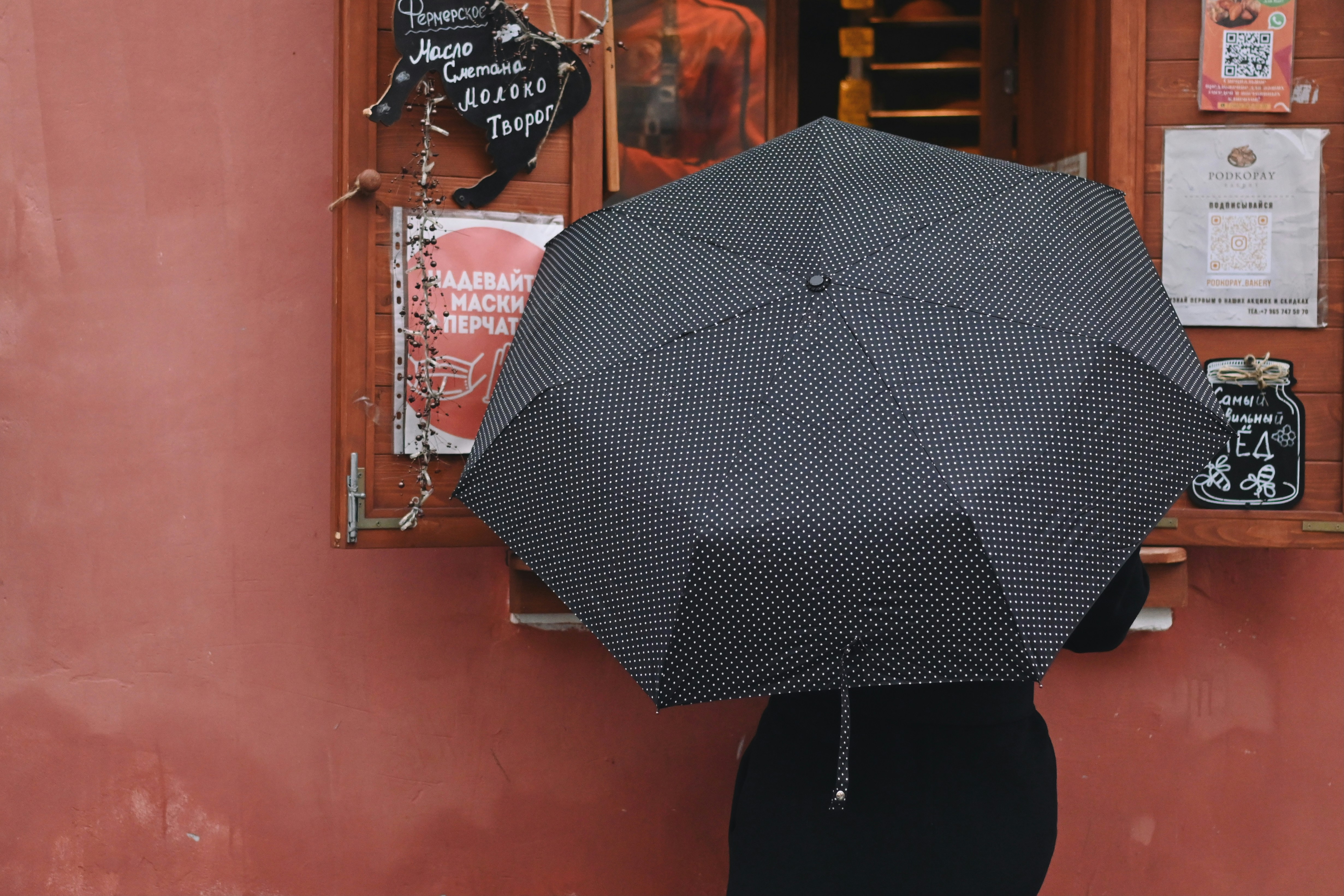 Closed umbrella leaning against a wall