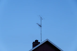 A professional installing a TV antenna on a rooftop.
