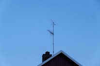 Technicians setting up a digital TV antenna on a rooftop.