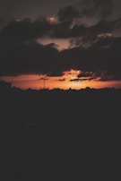 Album cover art featuring a moody crimson skyline with silhouetted cityscape.