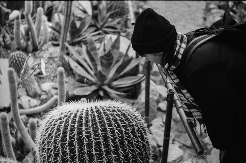 Foto en escala de grises de un hombre con sombrero negro y chaqueta negra