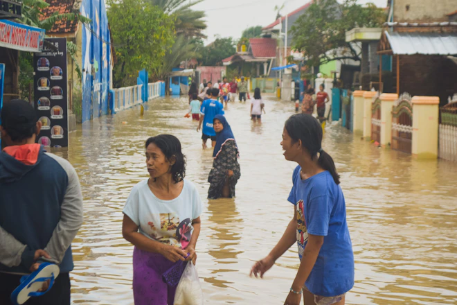 Seorang anak bertahan di genangan banjir yang melanda kampungnya
