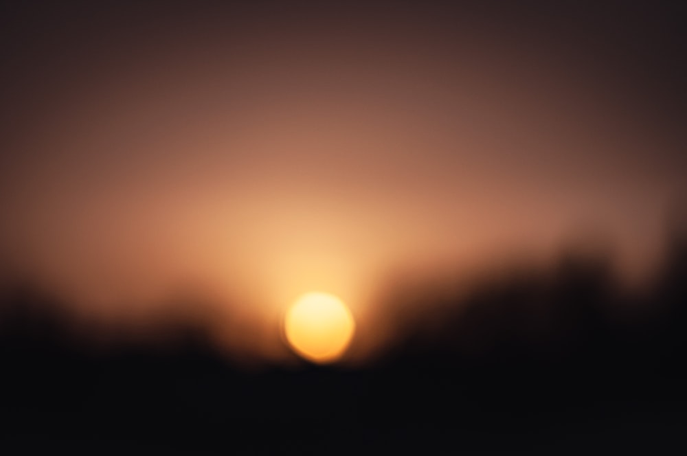 a blurry photo of the sun setting in the sky