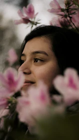 Soft pink-themed photo of Ananya smiling gently.