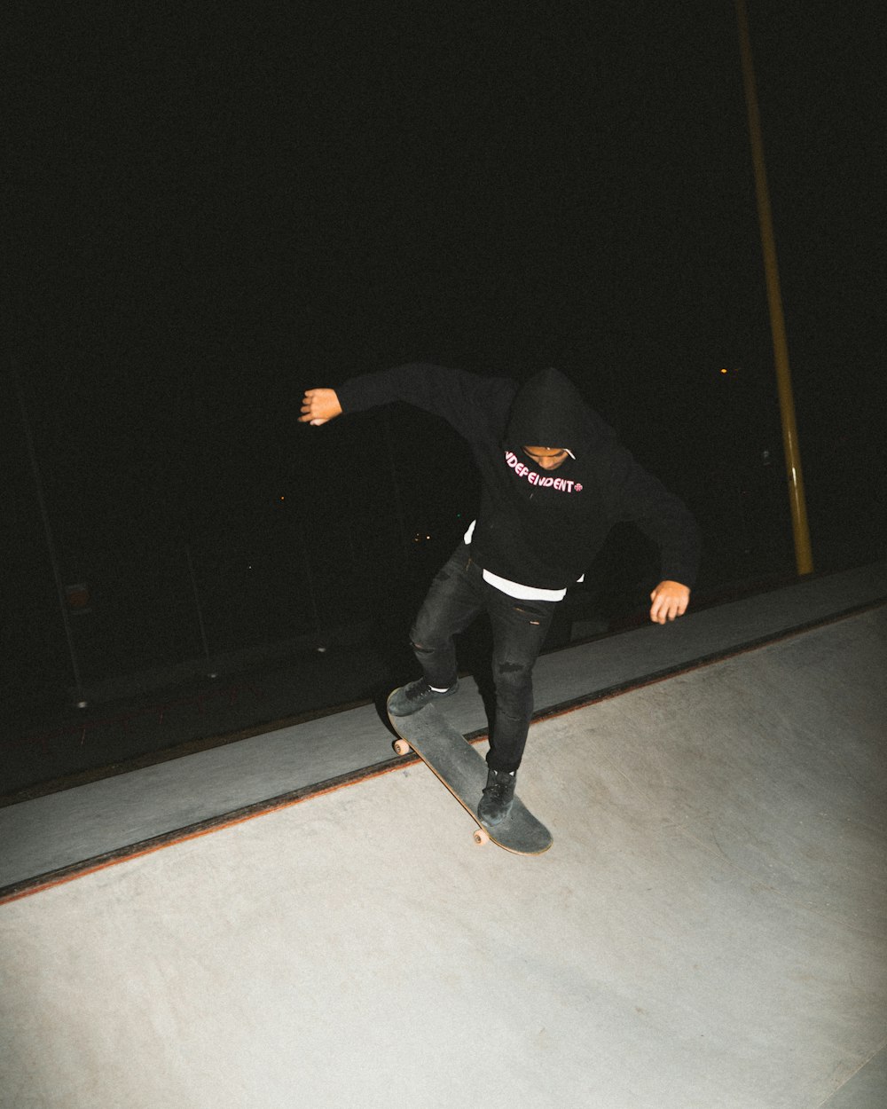 man in black jacket and black pants standing on gray concrete floor