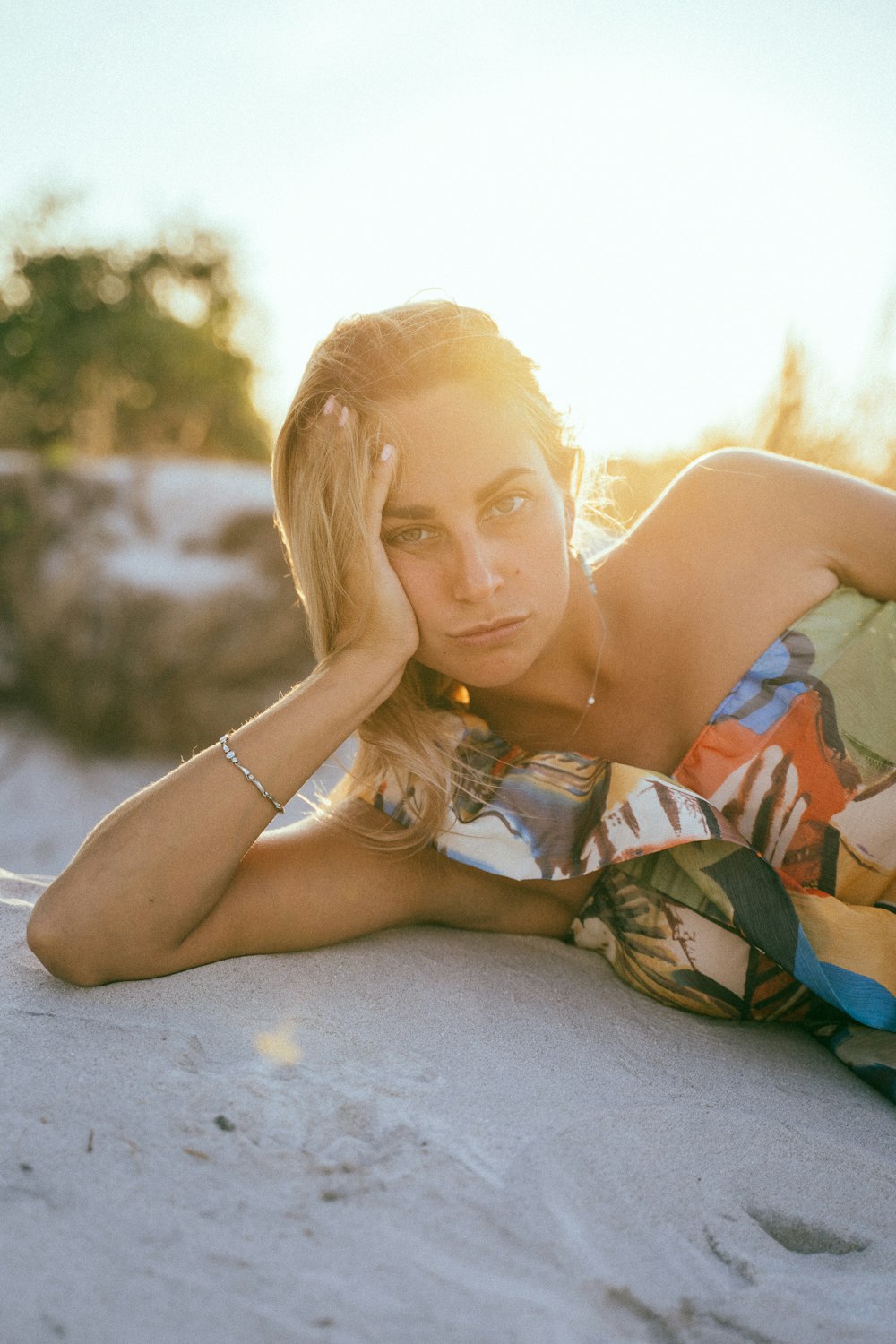 woman in blue and white floral dress lying on gray concrete floor