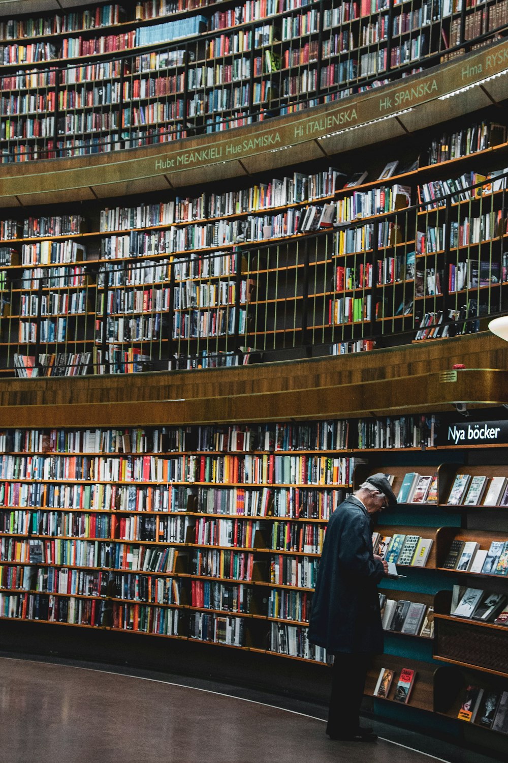 man in black suit standing in front of books on shelves