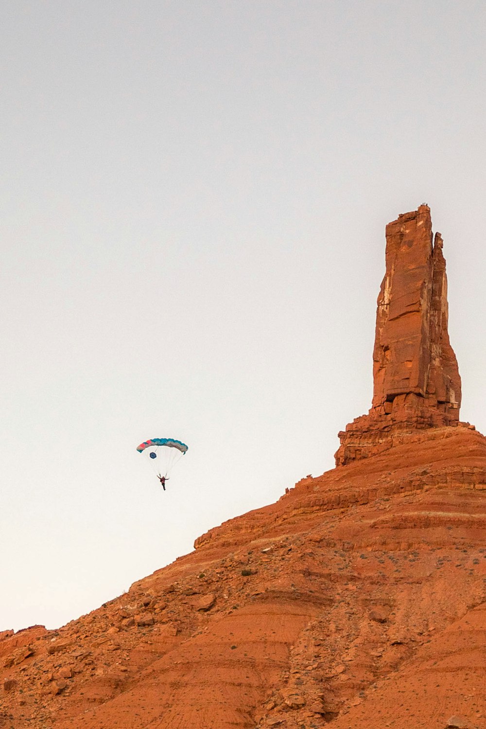 person in blue shirt on top of brown rock formation during daytime