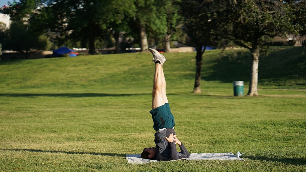 man in blue shorts and black shoes lying on ground