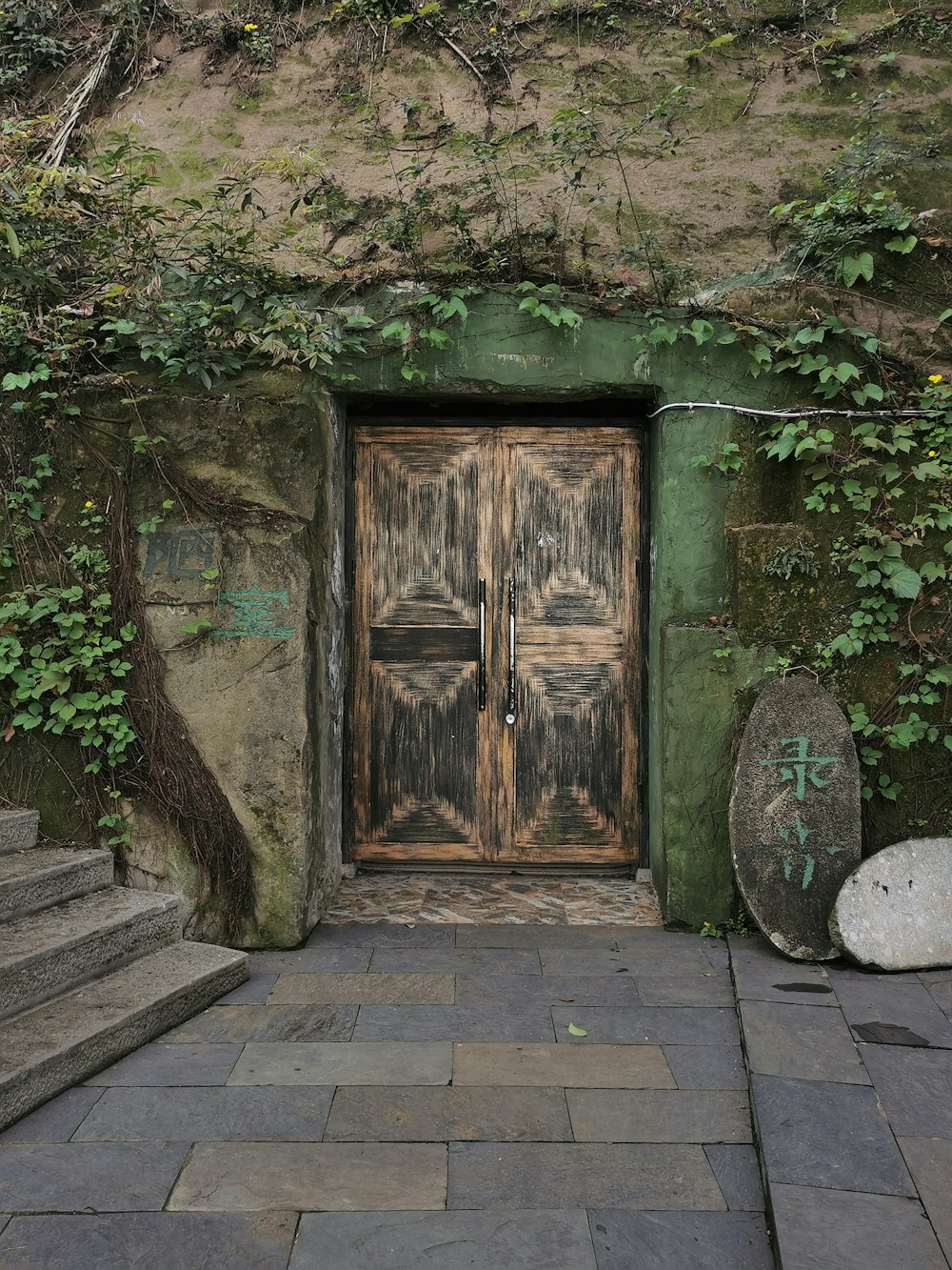 brown wooden door near green trees during daytime