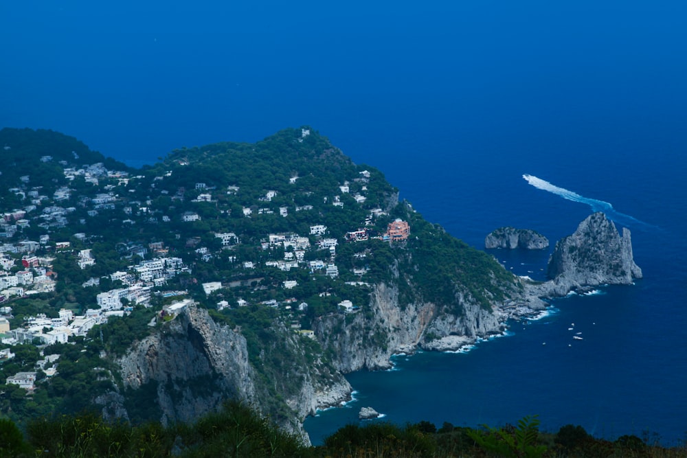 white and green mountain beside blue sea during daytime