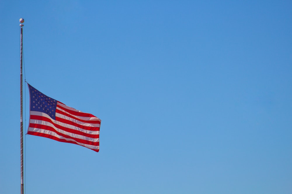 us a flag on pole under blue sky during daytime