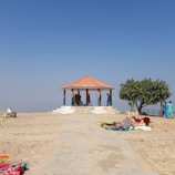 Local artisans teaching craft skills to community members under a shaded pavilion.