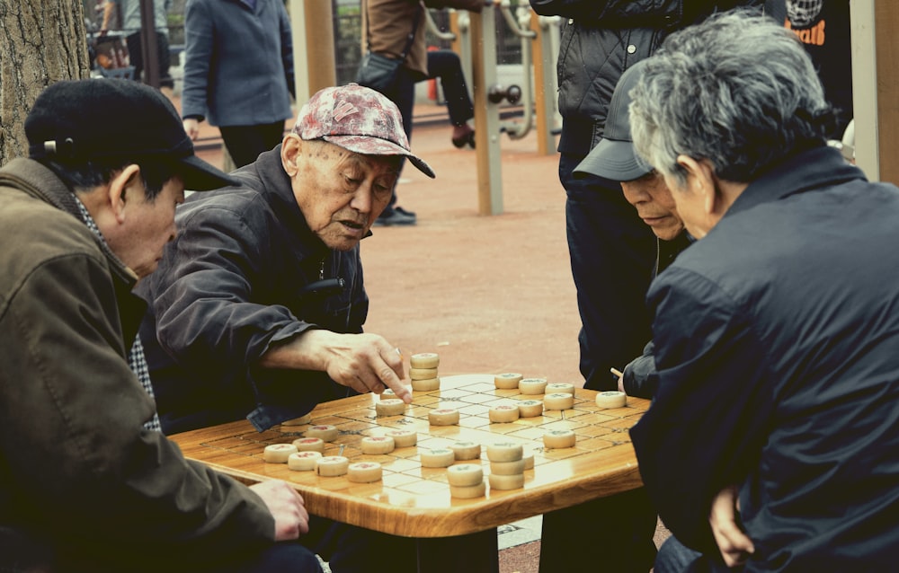 man in black jacket playing chess