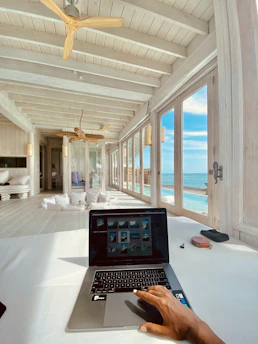 Close-up of a person reading a health and wellness blog on a sleek laptop in a bright, minimalist room.