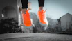 Child happily jumping while wearing colorful sneakers outdoors