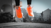 Close-up of running shoes hitting the pavement with orange and white colors