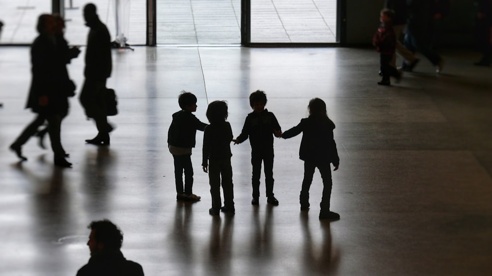 silhouette of people walking on white floor tiles