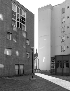 An urban street scene in monochrome, capturing shadows and light playing on architectural lines