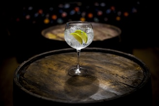 clear wine glass with yellow liquid on brown wooden table