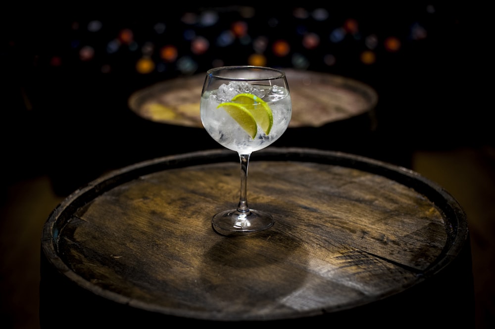 clear wine glass with yellow liquid on brown wooden table