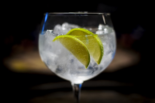 A close-up of a glass of anis carteluo with ice and a slice of lime.