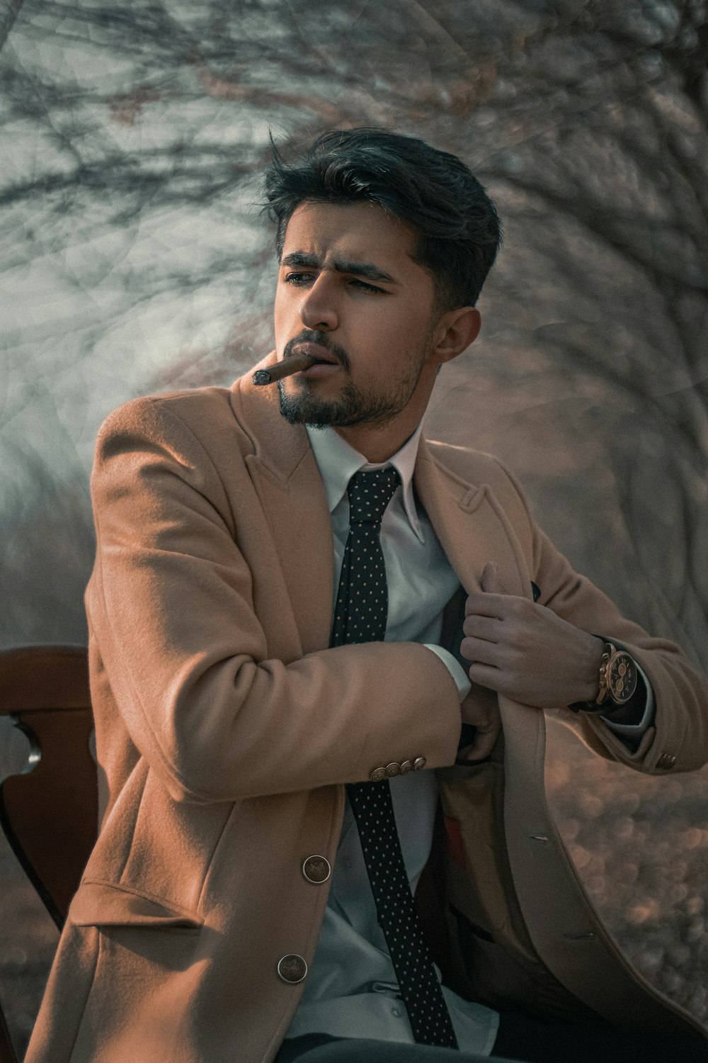 a man sitting on a bench smoking a cigarette