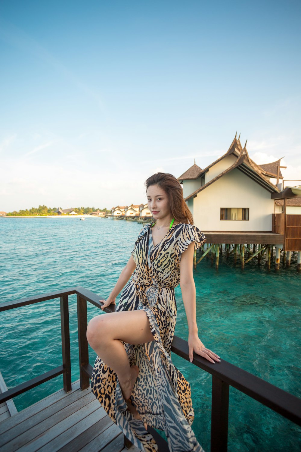 a woman standing on a dock next to a body of water