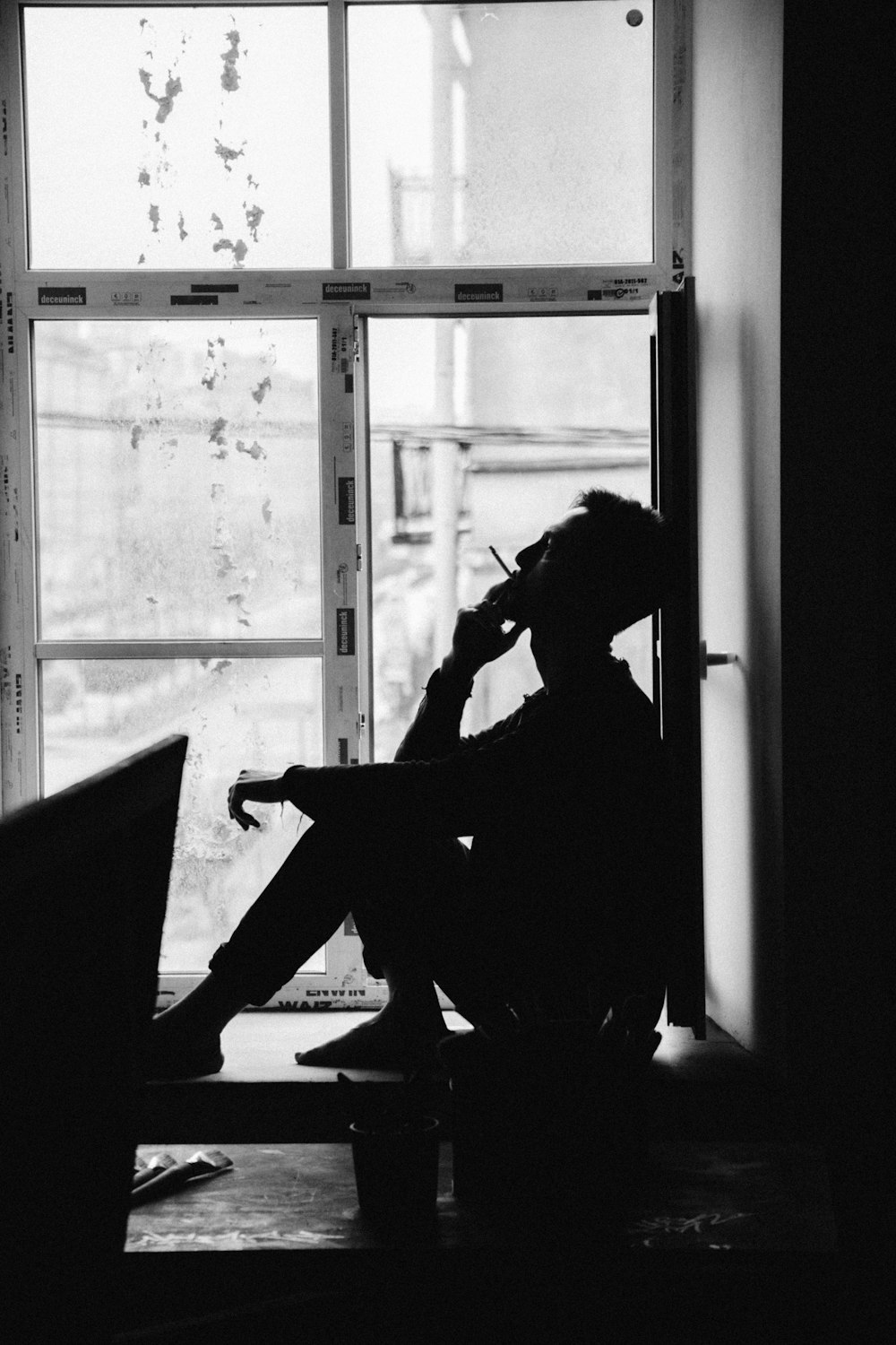 man sitting on chair near window