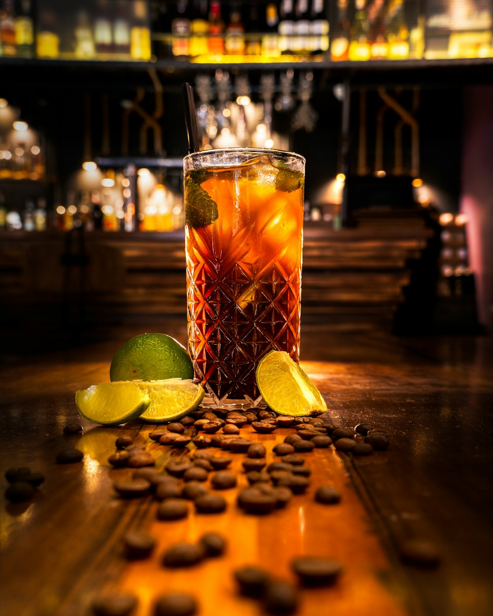 verre à boire transparent avec un liquide orange sur une table en bois brun