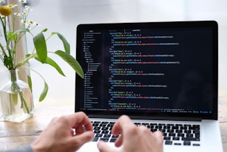 person using macbook pro on white table