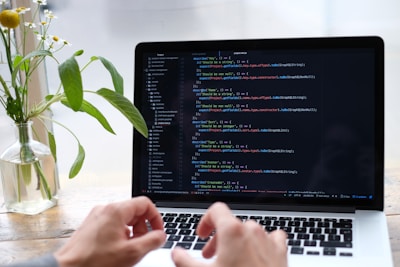 person using macbook pro on white table