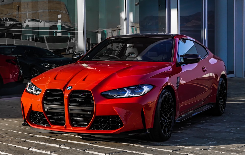 red bmw m 3 coupe parked on gray concrete pavement during daytime