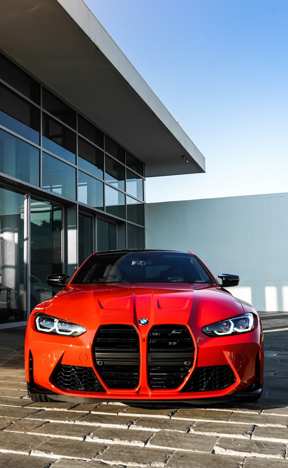 red bmw car parked near white building