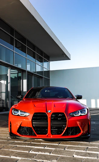 red bmw car parked near white building