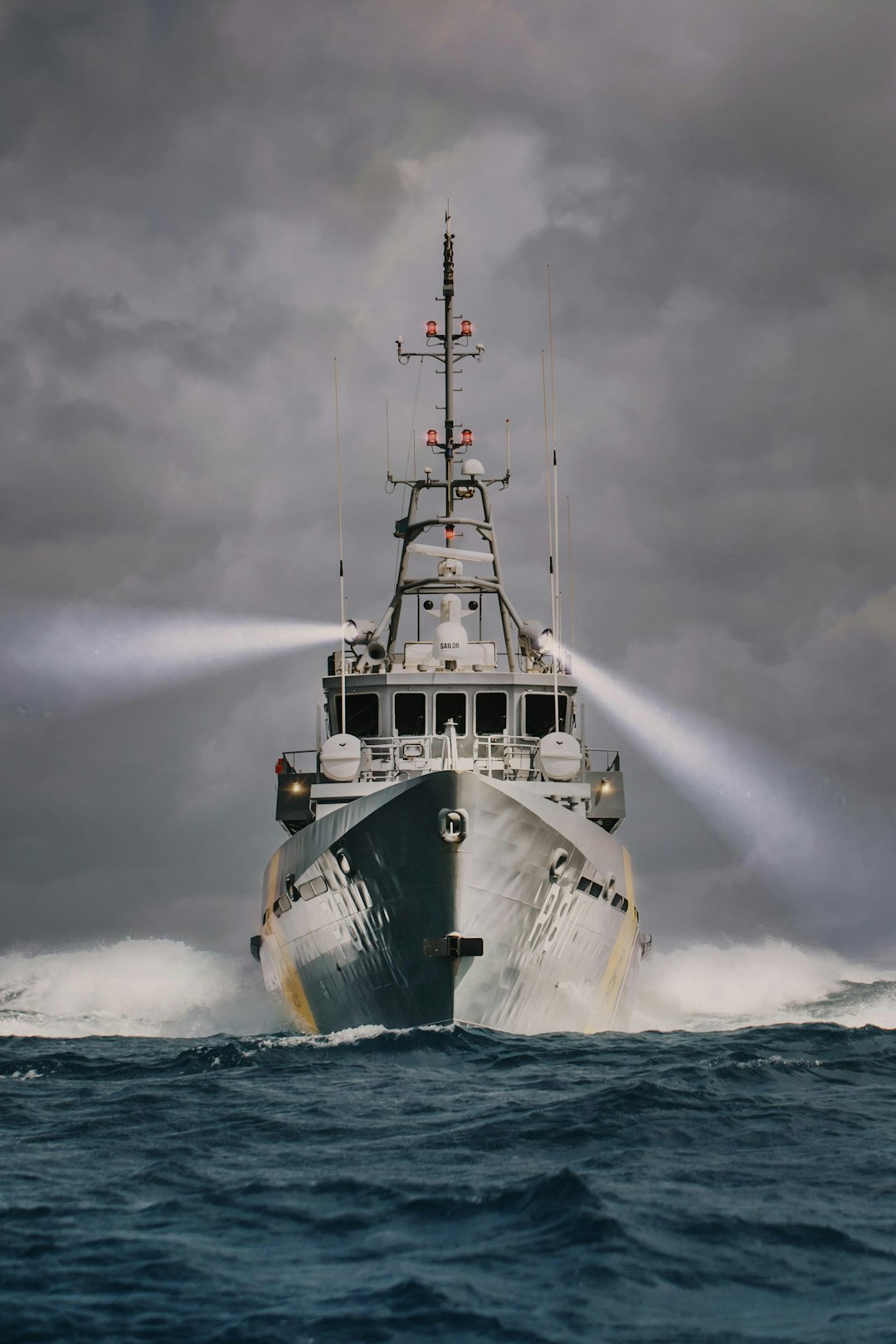 white and green ship on sea under gray clouds