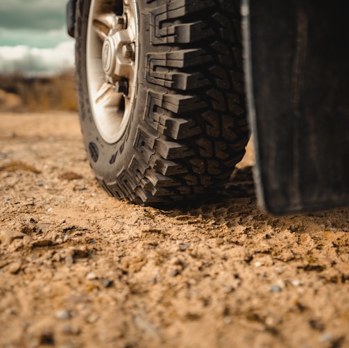 black car tire on brown sand during daytime