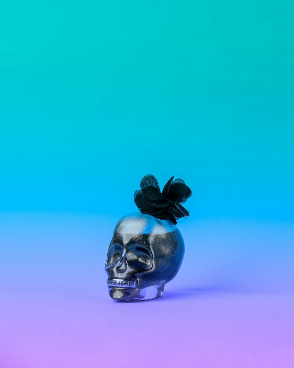 silver skull with purple flower on head figurine