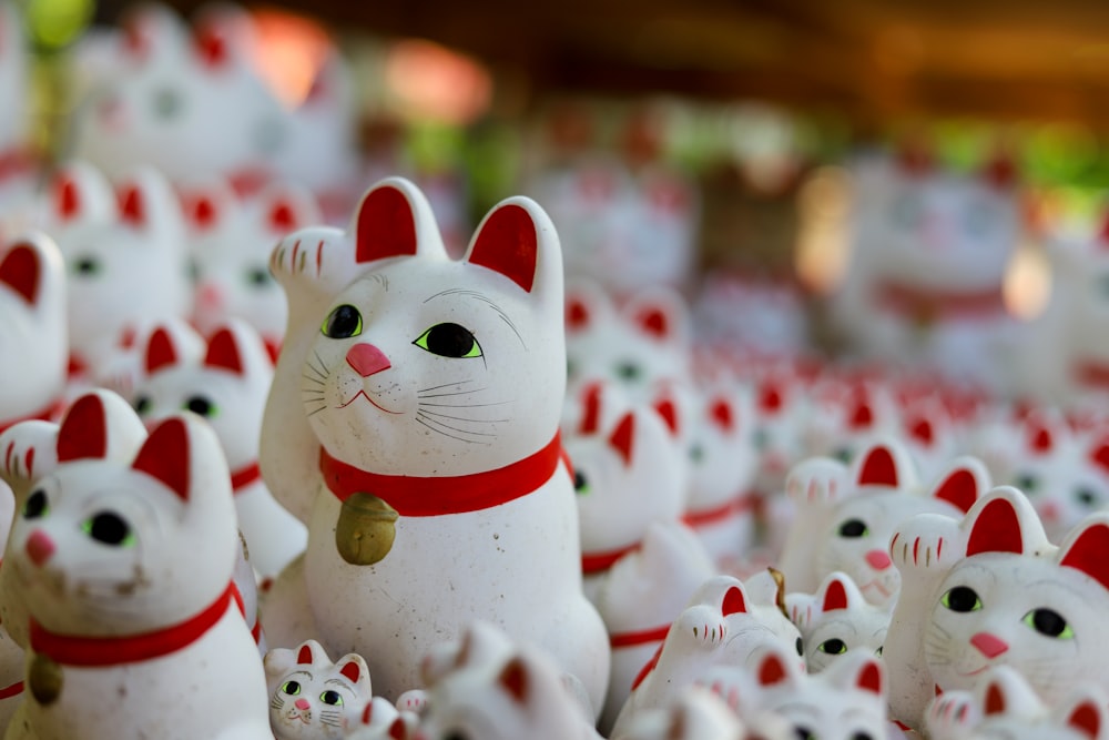Figurine in ceramica di gatti bianchi e rossi