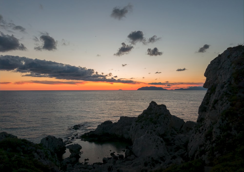 Las olas del mar rompiendo contra las rocas durante la puesta de sol