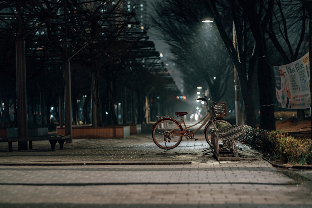 uma bicicleta estacionada ao lado de uma estrada ao lado de um banco